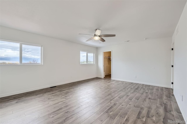 spare room with ceiling fan, a healthy amount of sunlight, and light hardwood / wood-style flooring