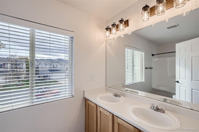 full bathroom with toilet, vanity, and tiled shower / bath