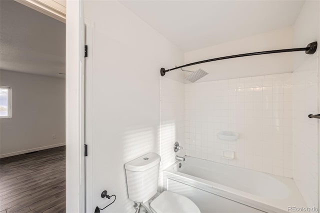 bathroom featuring hardwood / wood-style floors, tiled shower / bath, and toilet