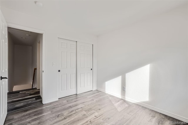 unfurnished bedroom featuring a closet and light wood-type flooring