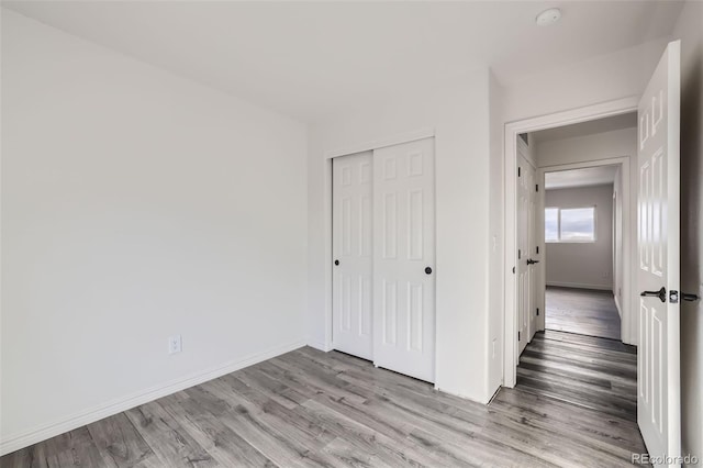 unfurnished bedroom with light hardwood / wood-style floors and a closet