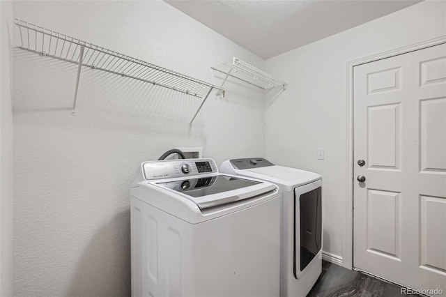 laundry area with washer and dryer and dark hardwood / wood-style floors