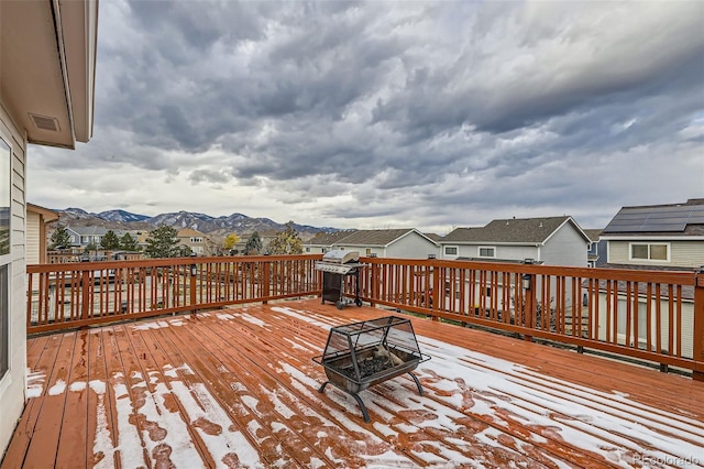 wooden terrace with grilling area, an outdoor fire pit, and a mountain view