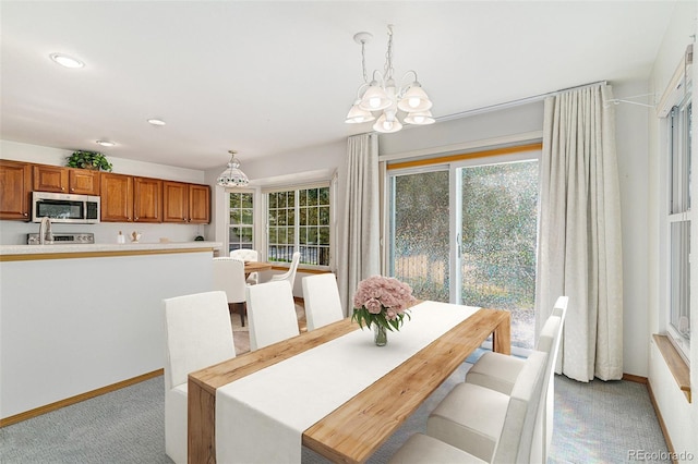 dining area featuring light carpet and a notable chandelier