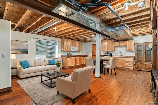 living room featuring hardwood / wood-style flooring and sink