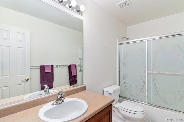 full bathroom with vanity, toilet, and combined bath / shower with glass door