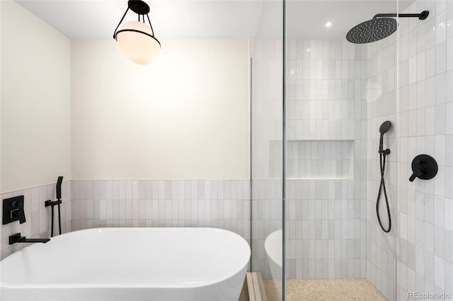 bathroom featuring a freestanding bath, tile walls, and a tile shower