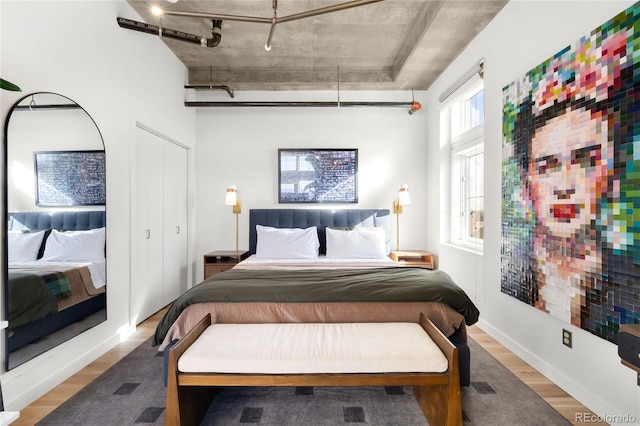 bedroom with baseboards and wood finished floors