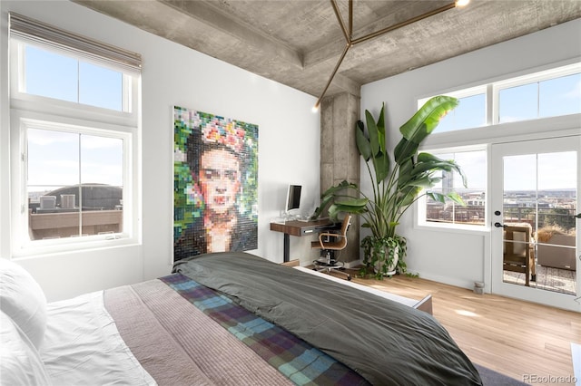 bedroom featuring wood finished floors and access to exterior