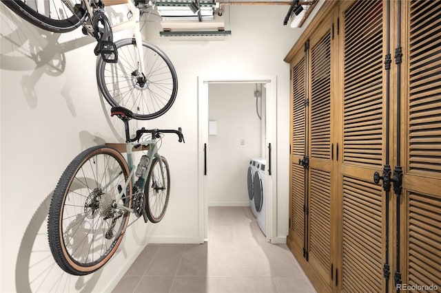 clothes washing area featuring washer and dryer, baseboards, laundry area, and tile patterned flooring