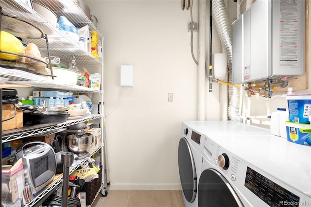 laundry room featuring washing machine and clothes dryer, baseboards, water heater, laundry area, and light tile patterned flooring