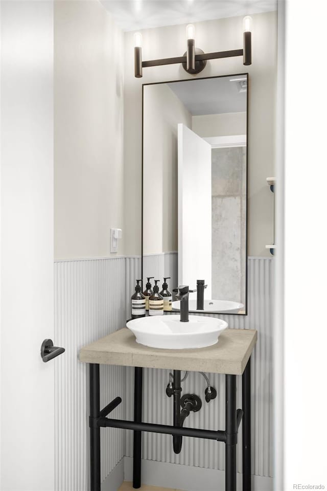 bathroom with a wainscoted wall and a sink