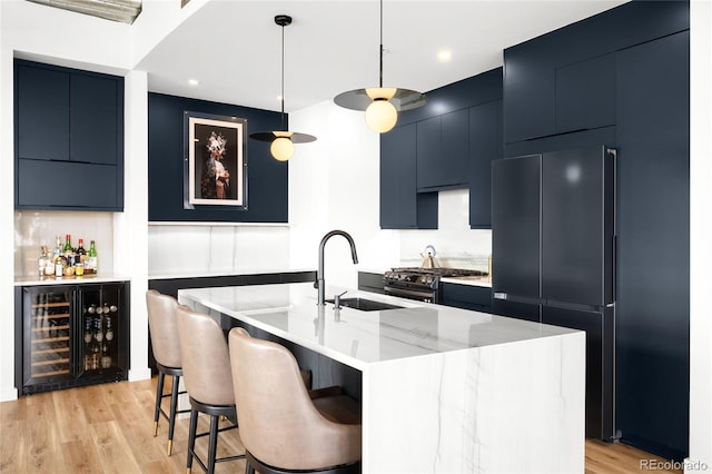 kitchen with beverage cooler, gas stove, modern cabinets, and freestanding refrigerator