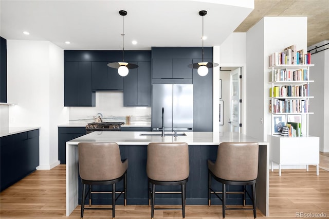 kitchen featuring a kitchen breakfast bar, modern cabinets, light wood finished floors, and stainless steel refrigerator