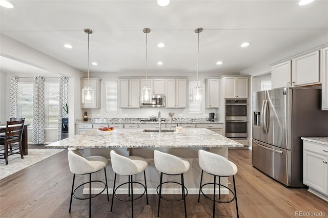 1101 E Witherspoon Dr, Elizabeth, CO 80107 - kitchen featuring decorative light fixtures, a kitchen island with sink, appliances with stainless steel finishes, and a breakfast bar