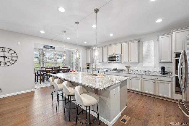 1101 E Witherspoon Dr, Elizabeth, CO 80107 - kitchen featuring a breakfast bar area, stainless steel appliances, dark wood-style flooring, and a sink