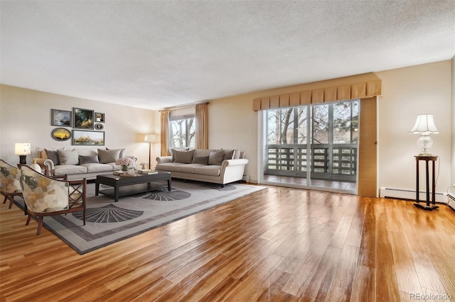 350 S Clinton St Unit 9C, Denver, CO 80247 - living room featuring wood finished floors, a baseboard radiator, and a textured ceiling