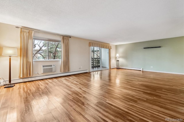 350 S Clinton St Unit 9C, Denver, CO 80247 - unfurnished living room with wood finished floors, baseboard heating, a baseboard radiator, baseboards, and a wall unit AC
