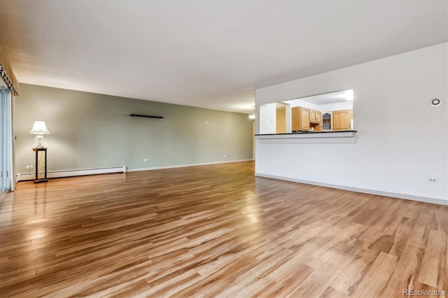 350 S Clinton St Unit 9C, Denver, CO 80247 - unfurnished living room with light wood-type flooring, baseboards, and baseboard heating