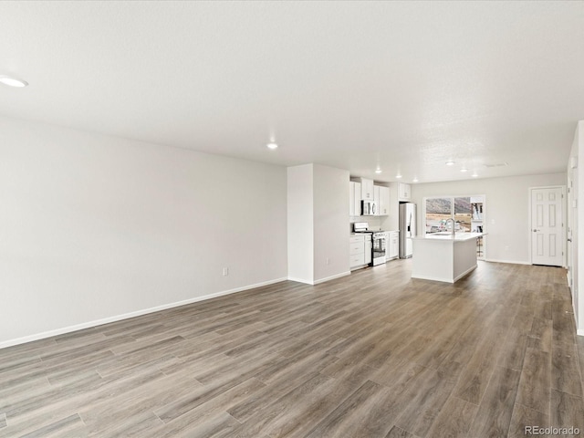 4761 Talley St, Morrison, CO 80465 - unfurnished living room with wood finished floors, a sink, baseboards, and recessed lighting