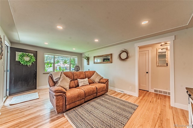 living area featuring light wood-style floors, baseboards, and recessed lighting