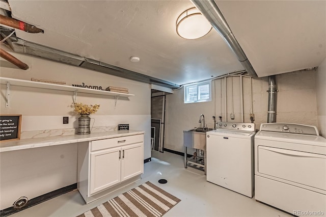 clothes washing area with washer and clothes dryer and cabinet space