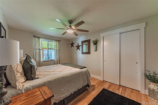 bedroom featuring light wood finished floors, baseboards, ceiling fan, and a closet