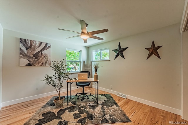 home office with ceiling fan, light wood-type flooring, and baseboards