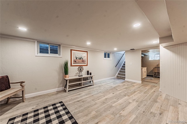 below grade area featuring light wood-style flooring, stairs, recessed lighting, and baseboards