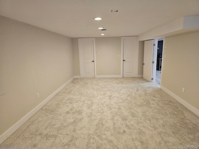 spare room with recessed lighting, light colored carpet, and baseboards