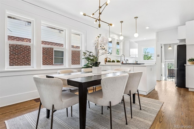 dining area featuring light wood finished floors, baseboards, and recessed lighting