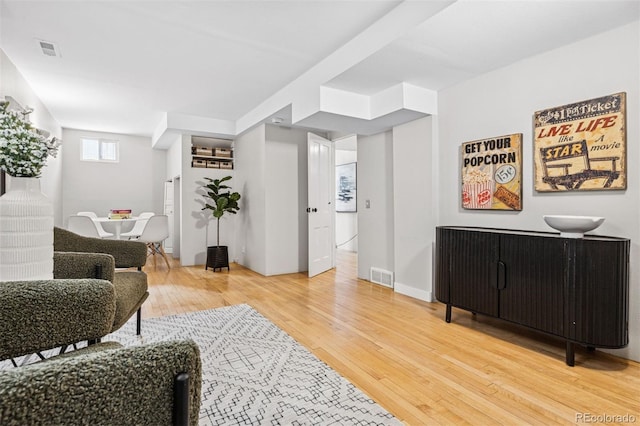 living room with light wood-style flooring and visible vents