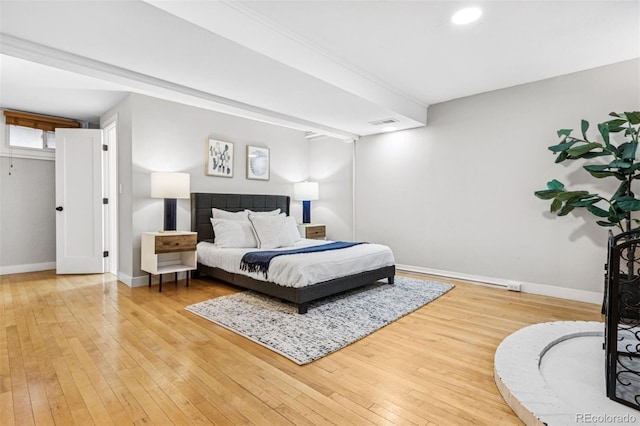 bedroom featuring light wood finished floors, visible vents, and baseboards