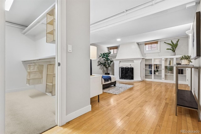 unfurnished living room with baseboards, hardwood / wood-style floors, and a fireplace