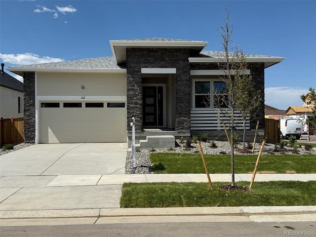1111 Joseph Pl, Erie, CO 80026 - prairie-style house with a garage, driveway, stone siding, and a shingled roof