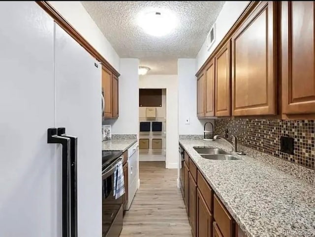 kitchen featuring sink, electric range, white refrigerator, light stone countertops, and light hardwood / wood-style floors