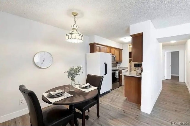 dining space featuring hardwood / wood-style floors and a textured ceiling