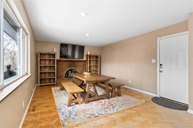 dining space with a fireplace and light parquet flooring