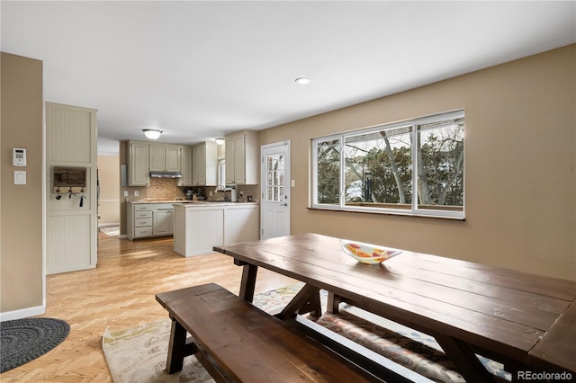 dining room with sink and light parquet floors