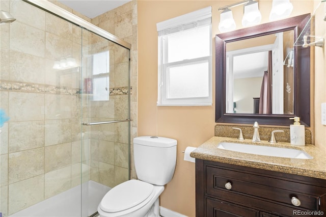 bathroom featuring vanity, toilet, and an enclosed shower