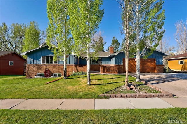 45 E Mikado Dr, Colorado Springs, CO 80919 - view of front of home with board and batten siding, brick siding, driveway, a garage, and a front yard