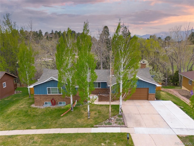 45 E Mikado Dr, Colorado Springs, CO 80919 - view of front of home with brick siding, concrete driveway, an attached garage, a lawn, and board and batten siding