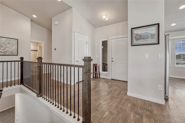 hall featuring wood-type flooring and lofted ceiling