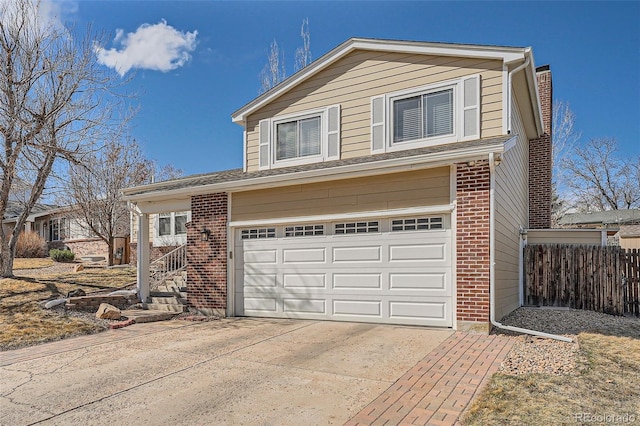 traditional home with brick siding, fence, driveway, and an attached garage