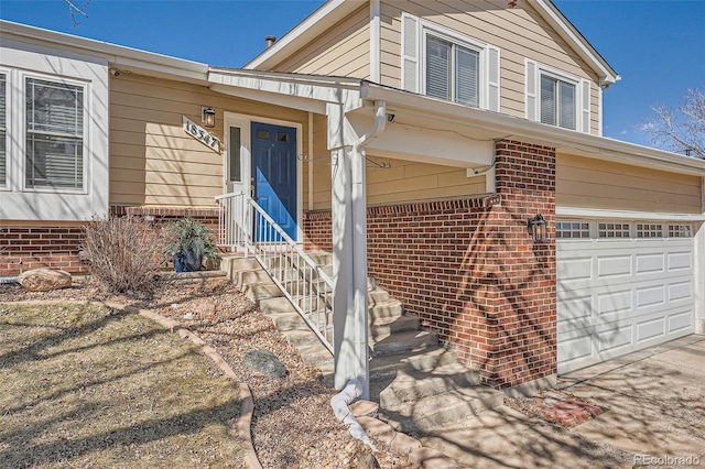 property entrance with driveway and brick siding