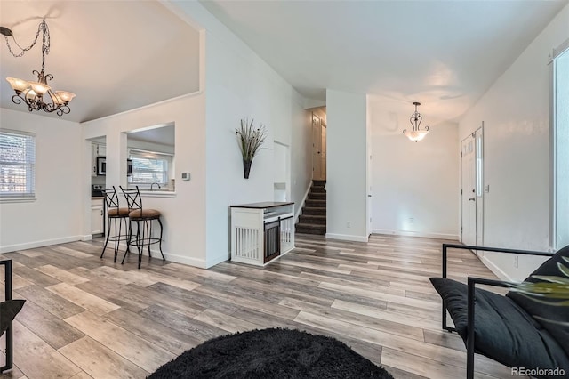 kitchen featuring light wood-type flooring, plenty of natural light, a chandelier, and baseboards