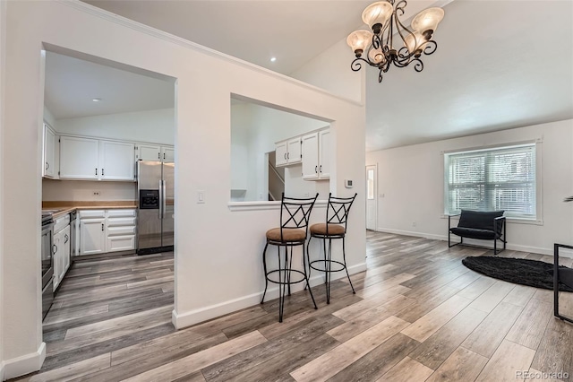 kitchen featuring stainless steel appliances, light wood-type flooring, white cabinetry, and baseboards