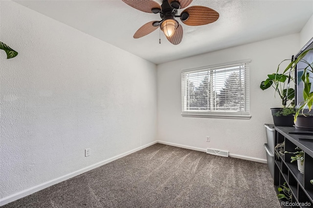 empty room featuring baseboards, visible vents, a ceiling fan, a textured wall, and carpet floors