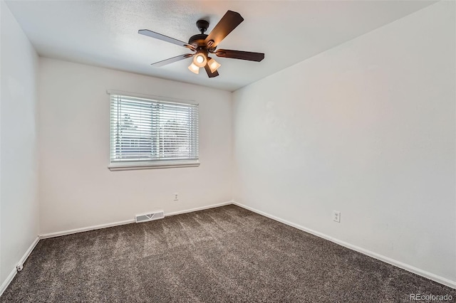 unfurnished room featuring ceiling fan, baseboards, visible vents, and dark colored carpet