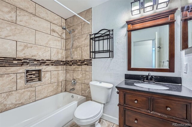 full bath featuring a textured wall, toilet, vanity, shower / tub combination, and baseboards